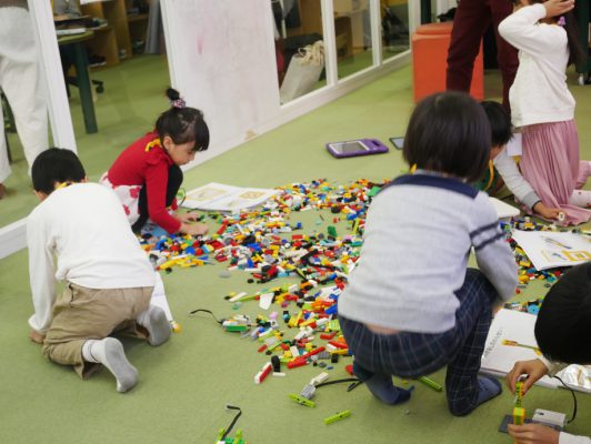 教室でレゴを組み立てている写真