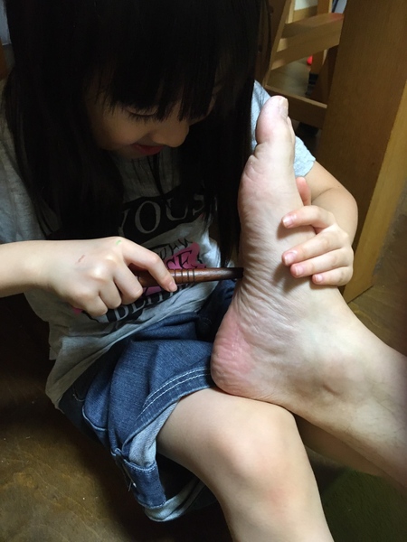 足を揉む娘